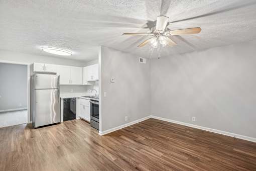 A kitchen with a refrigerator, oven, and sink.