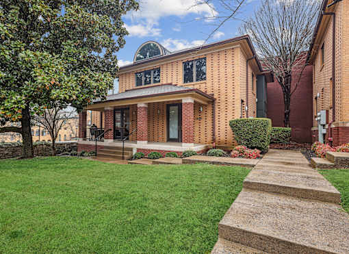 A house with a brick facade and a circular window on the top.