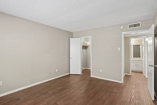 A room with a white door and a white cabinet with a mirror above it.