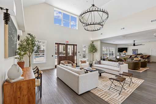 A clubhouse with a large sofa set and a chandelier.