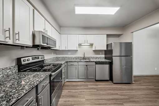 A kitchen with granite countertops and stainless steel appliances.