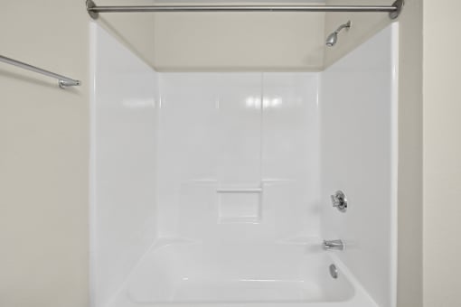 A white bathroom with a shower stall and a towel bar.