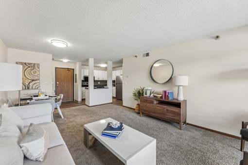 A living room with a grey couch and a white coffee table.
