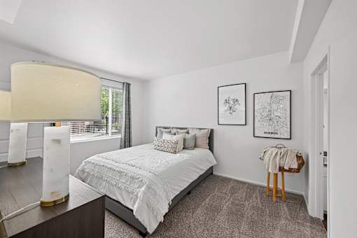 A bedroom with a large bed and two framed pictures on the wall.