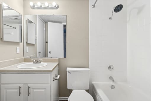 A white bathroom with a sink, toilet, and bathtub.