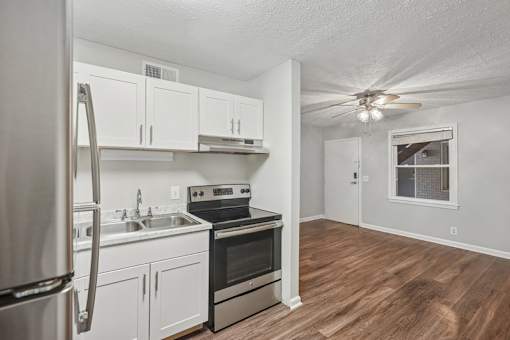 A kitchen with white cabinets and stainless steel appliances.