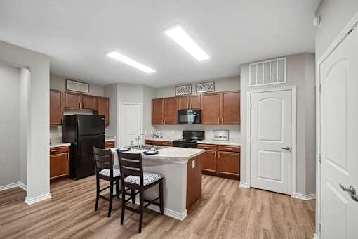 A kitchen with a black refrigerator and wooden cabinets.