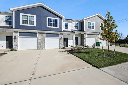 A two-story house with a garage and a driveway.