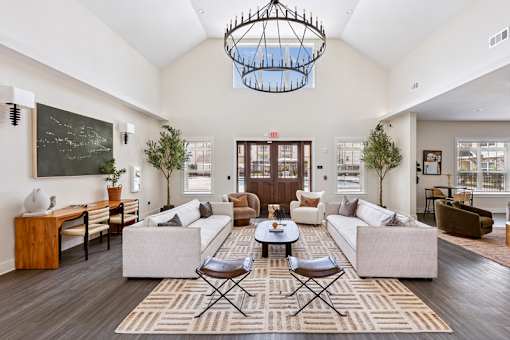 A clubhouse with a large rug and a chandelier.