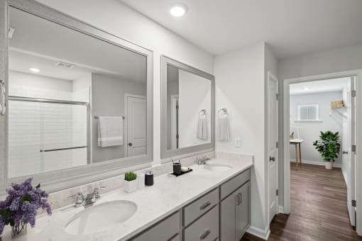a white bathroom with two sinks and mirrors