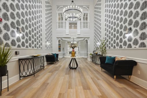 the lobby of a hotel with a large hall with chairs and a table
