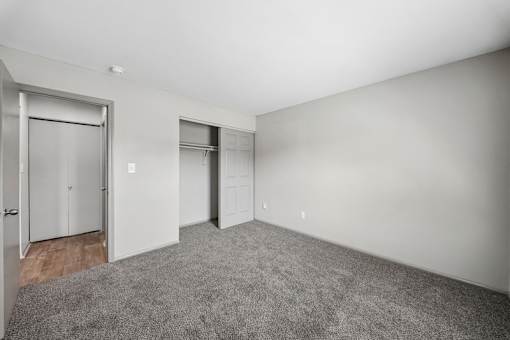 A room with a grey carpet and white walls.