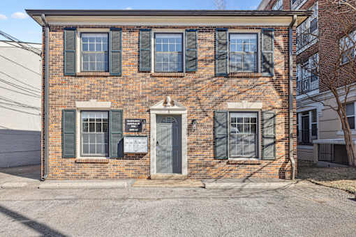A brick building with a sign on the front door.