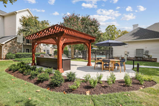 a pergola with a table and chairs in a backyard