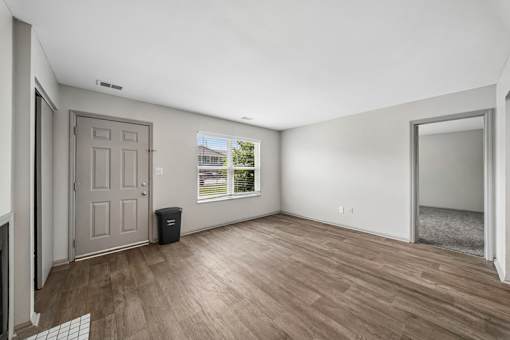 A room with a wooden floor and a door.