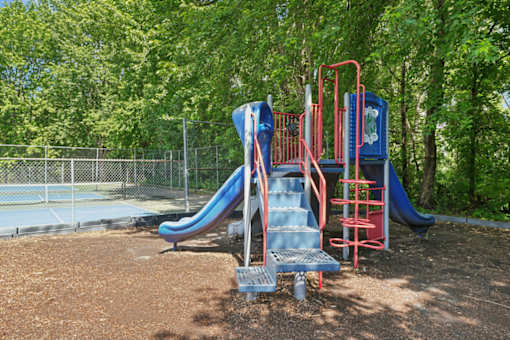 A playground with a blue slide and a red ladder.