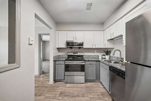 A modern kitchen with stainless steel appliances and white cabinets.
