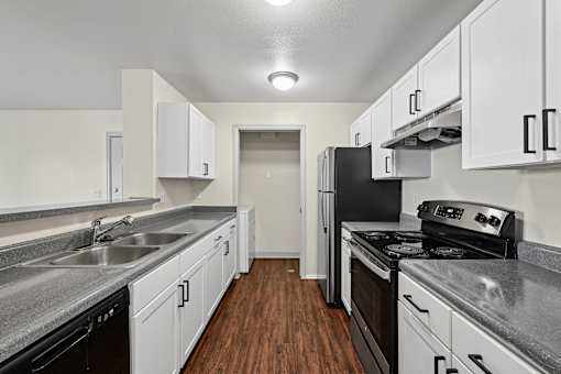 A kitchen with black appliances and white cabinets.
