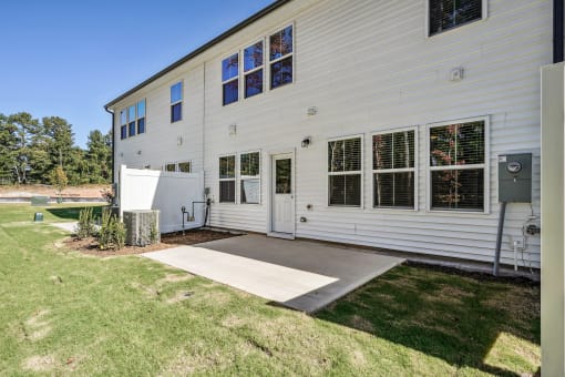 the outside of a white house with a concrete driveway