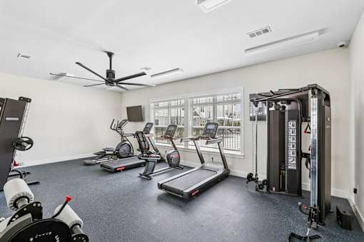 A spacious apartment community gym with a variety of exercise equipment.