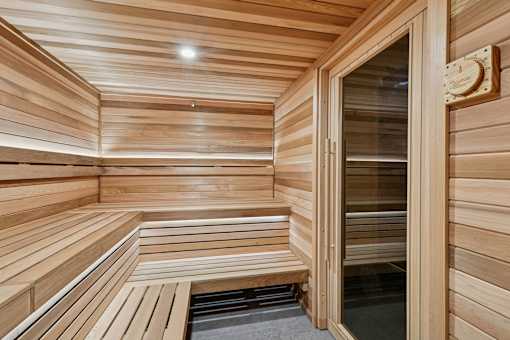 A wooden sauna with benches and a glass door.