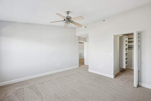 A room with a ceiling fan and a carpeted floor.