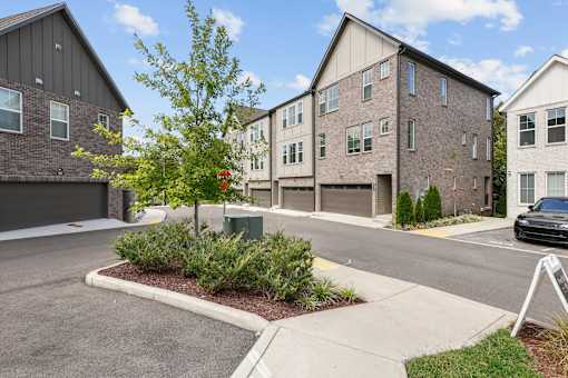 A tree in a planter is the only thing separating the street from the front yards of two houses.