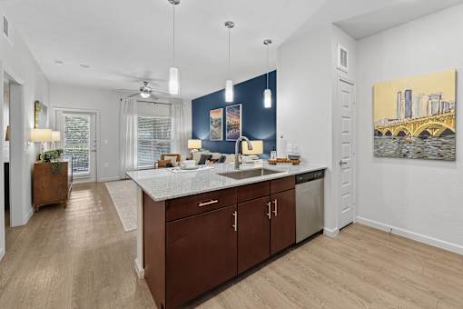 A kitchen with a large island and a painting of a cityscape on the wall.