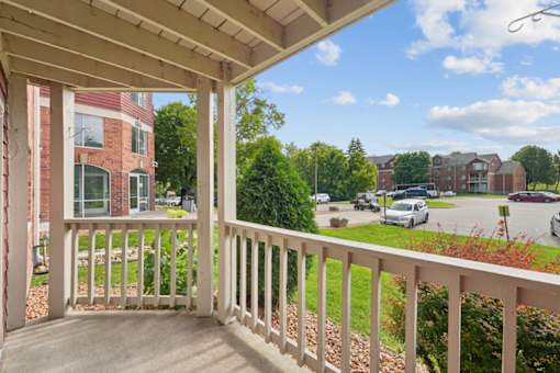 A view from a porch looking out at a parking lot.