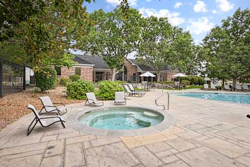 A pool with a hot tub in the middle of a backyard.