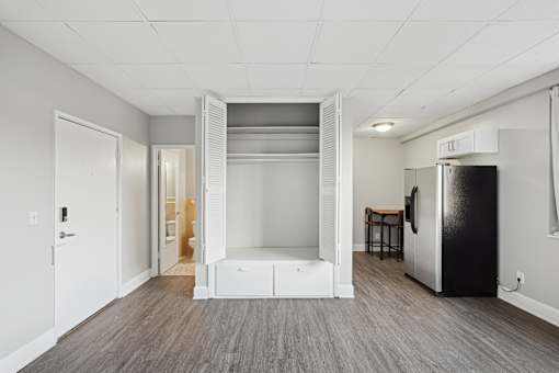 A kitchen with a refrigerator and a bar stool.