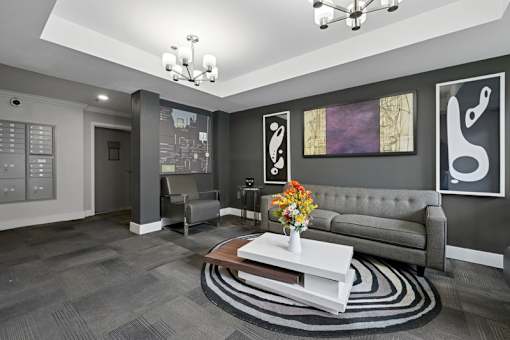A modern living room with a grey couch, a coffee table, and a chandelier.