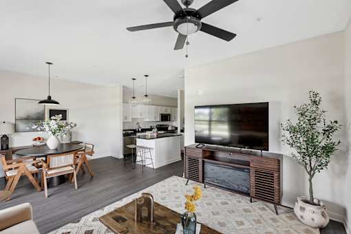 A modern living room with a wooden floor and a large flat screen TV.