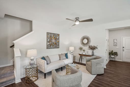 a living room with couches and chairs and a ceiling fan