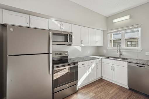 A modern kitchen with stainless steel appliances and white cabinets.