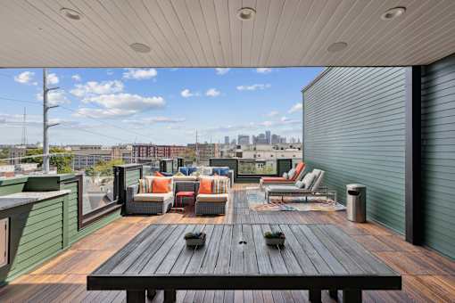 A wooden table is in the middle of a rooftop patio.