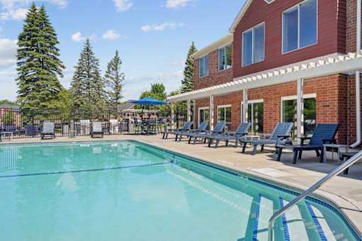 A large swimming pool with a building in the background.