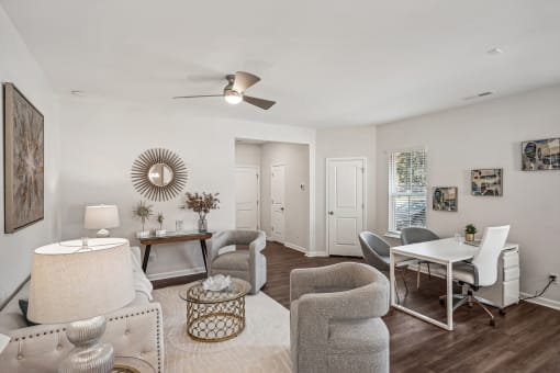 a living room with a dining room table and chairs and a ceiling fan