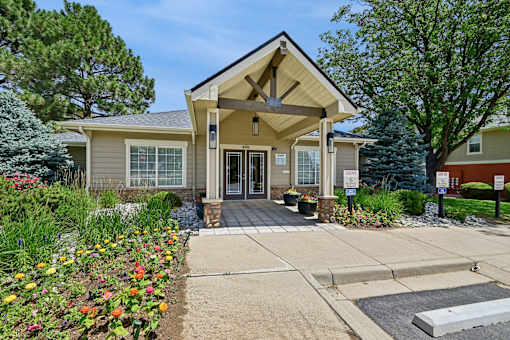 A building with a front porch and a small garden in front.