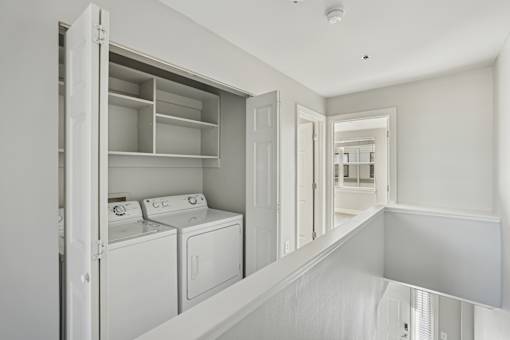 A white laundry room with a washer and dryer.