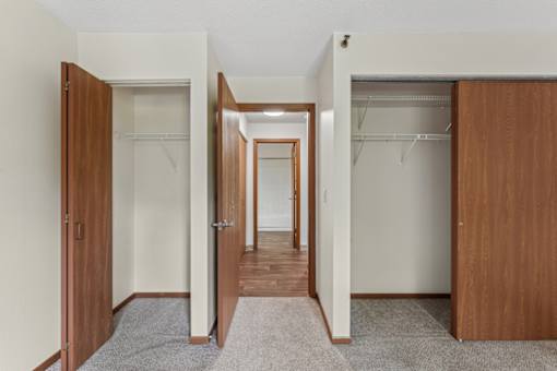 A hallway with a carpeted floor and white walls.