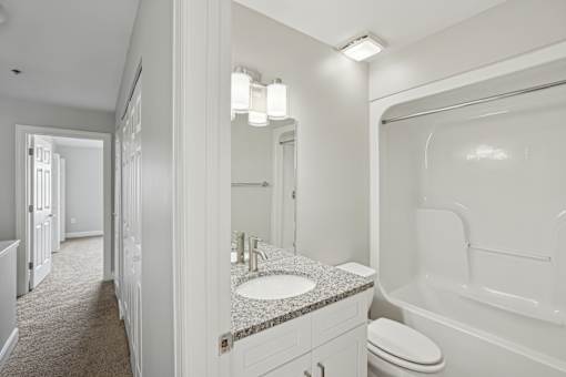 A white bathroom with a sink, toilet, and bathtub.