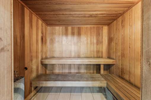 A wooden sauna with a bench in the middle.