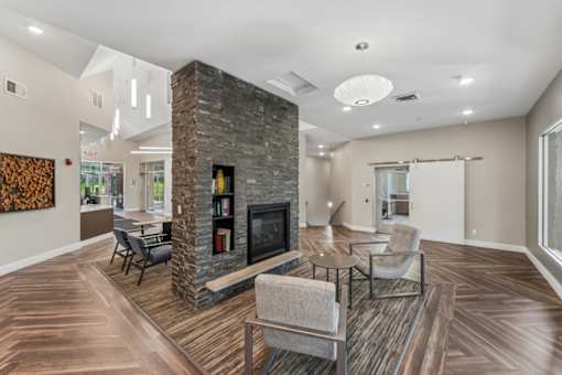 A living room with a stone fireplace and a grey sofa.
