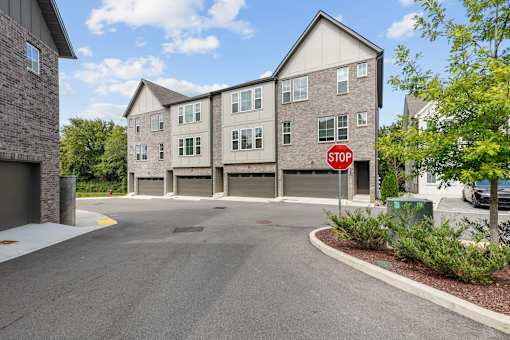 A stop sign is on the side of a road in front of a building.