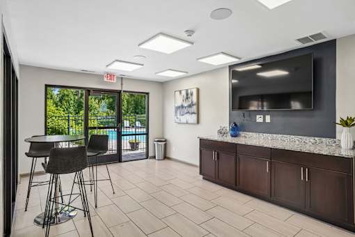 A room with a bar area and a television.