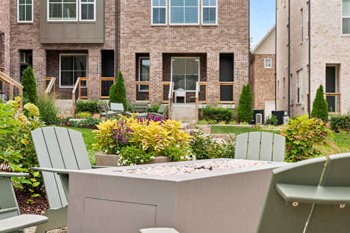 A patio with chairs and a table in front of a building.