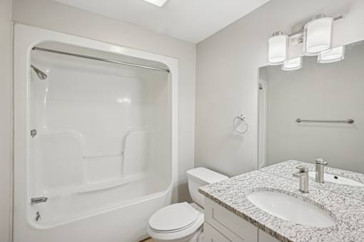 A white bathroom with a sink, toilet, and bathtub.