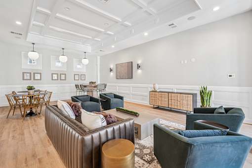A living room with a brown sofa, a wooden table, and a TV mounted on the wall.
