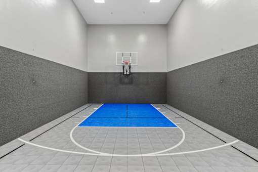 A basketball court with a blue floor and a white wall.